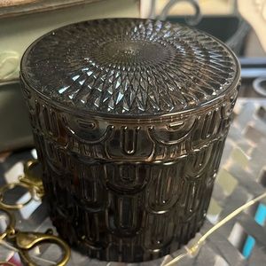 Black candle in black glass jar with lid